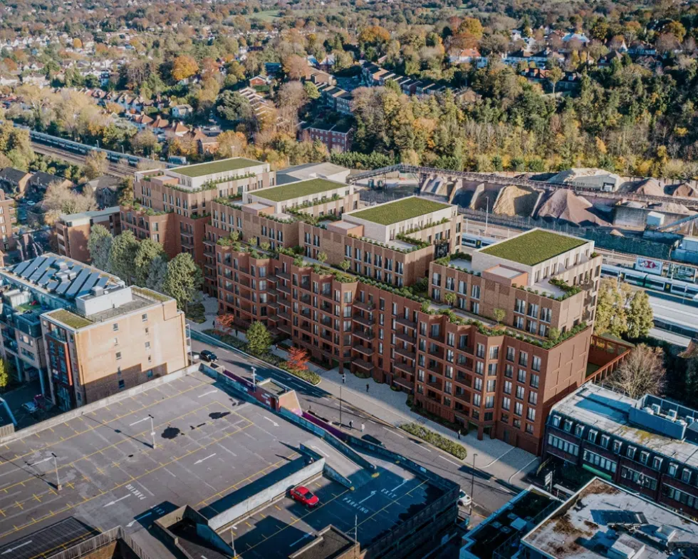 Aerial view of urban development with green rooftops.
