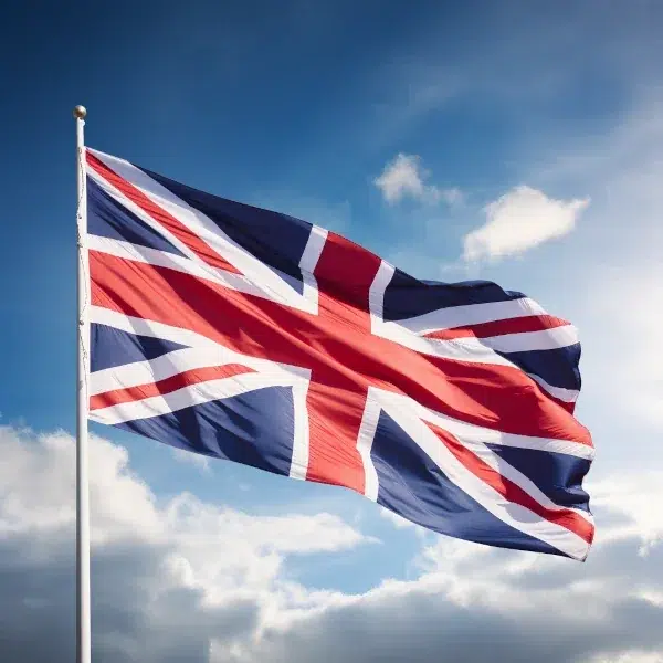 Union Jack flag waving against cloudy sky.